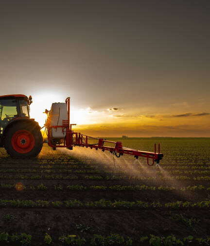 Tractor spraying pesticides on soybean field  with sprayer at spring